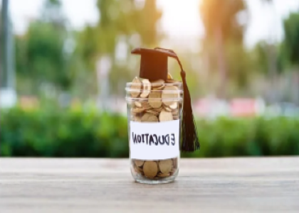 jar of coins labeled "education" with graduation cap on top 
